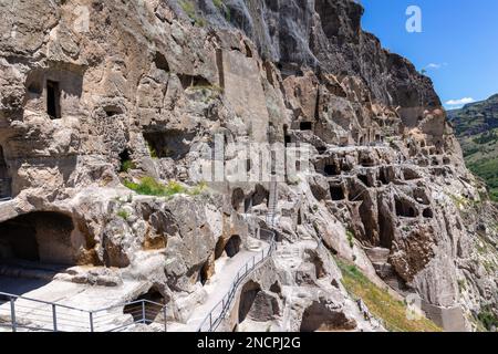 Vardzia cave monastery complex in Georgia, mountain slope with caves, tunnels and dwellings carved in the rock, Kura river valley in the background. Stock Photo