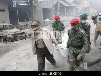 Rescuers carry the body of a victim of Mount Merapi eruption in ...