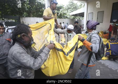 Rescuers carry the body of a victim of Mount Merapi eruption in ...