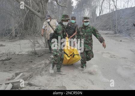 Rescuers carry the body of a victim of Mount Merapi eruption in ...