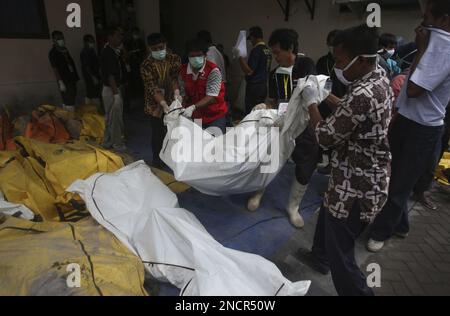 Rescuers carry the body of a victim of Mount Merapi eruption in ...