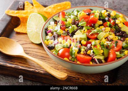 Homemade Texas Caviar Bean Dip with Chips closeup in the bowl on the wooden board. Horizontal Stock Photo