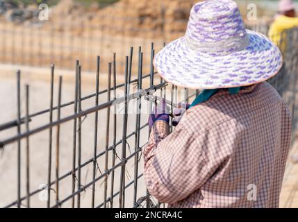 Worker bundle wire steel rod in construction site. Stock Photo