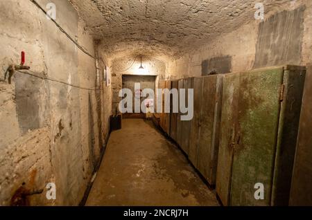 Hermetic rusty door of the bunker in underground abandoned tunnel. Mysterious old iron gate. Secret entrance Stock Photo