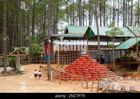 Students run across the yard at Coconut School, which is built from recycled plastic, bottles and rubber tires in Kampong Speu, Cambodia. Stock Photo
