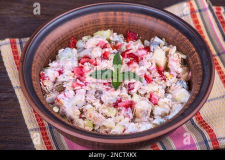 Muesli with lots of dry fruits, nuts, berries and grains in pate, close up Stock Photo