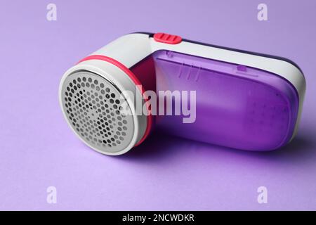 Modern fabric shaver for lint removing on purple background Stock Photo