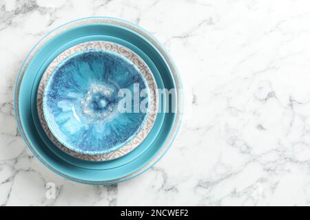 Elegant new empty dishes on white marble table, top view. Space for text Stock Photo