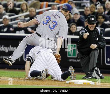 First base umpire Angel Hernandez, right, makes the out call as Texas  Rangers starting pitcher Cliff Lee (33) falls over New York Yankees' Brett  Gardner for an out to end the third