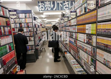 Salarymen or Japanese male office workers look at secondhand books in a Book off Store in Meguro, Tokyo Japan. Stock Photo