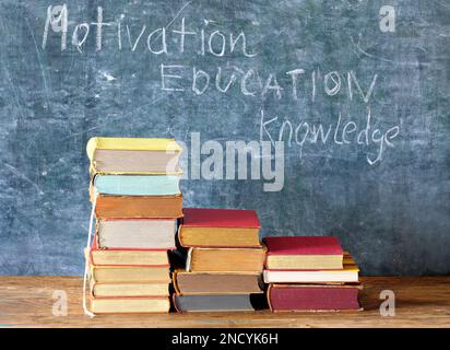 motivation,education,knowledge, books in front of blackboard,concept. Stock Photo