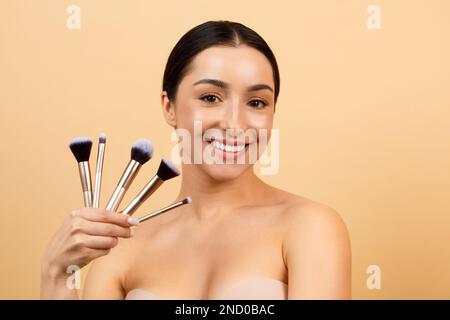 Beauty Concept. Attractive Indian Female With Set Of Makeup Brushes In Hand Stock Photo