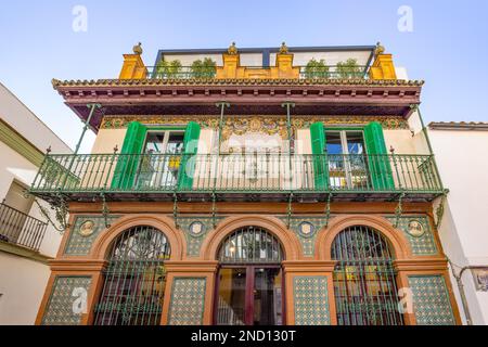 Beautiful old building with green balcony, with ceramic tiles on the facade and wrought iron balconies in the center of the old town of Triana Neighbo Stock Photo