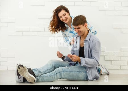 Smiling husband and wife sit taking care of utility bills and house maintenance documents, happy young couple read paperwork Stock Photo