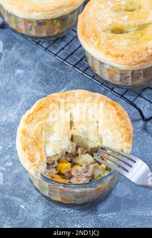 Individual beef pot pies or deep dish pies in ramekin and on a cooling ...