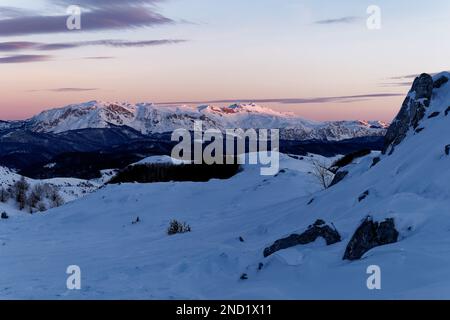 Amazing view of different mountain peaks with snow during winter. Beautiful sunset of the mountain range and amazing attraction for alpine climbers. Stock Photo