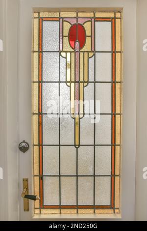 White door with glass window decorated by ornamental details in modern light apartment Stock Photo