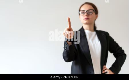 Defocused woman in glasses touching virtual interface, infographic, screen with finger. Stock Photo