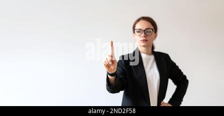 Female business person in background touching virtual interface with her hand. Stock Photo