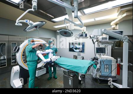 15 February 2023, Saxony-Anhalt, Halle (Saale): Senior physician Bernhard Ullrich (l) and Christoph Wilhelm in the operating room with the new robot. Bergmannstrost Hospital in Halle is putting a new robotic surgical operating system into operation. It also features a 3D imaging robot and a digital navigation system. Photo: Heiko Rebsch/dpa Stock Photo