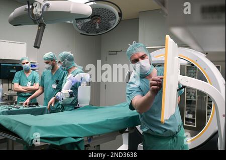 15 February 2023, Saxony-Anhalt, Halle (Saale): A surgical team demonstrates the new robot at a press event in the operating room. Bergmannstrost Hospital in Halle is putting a new robotic surgical operating system into operation. It also features a 3D imaging robot and a digital navigation system. Photo: Heiko Rebsch/dpa Stock Photo