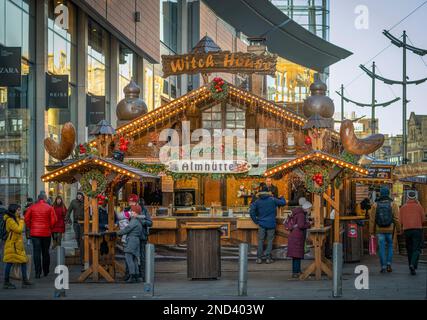 Large wooden chalet style stall selling bratwurst. Manchester Christmas markets. UK Stock Photo