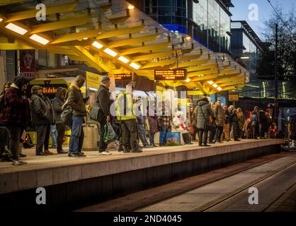 Passengers waiting at Exchange Square tram stop at dusk in Manchester. Stock Photo