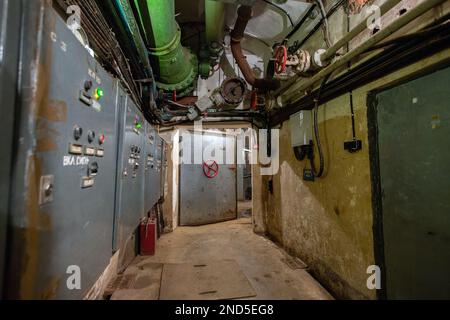 Hermetic rusty door of the bunker in underground abandoned tunnel. Mysterious old iron gate. Secret entrance Stock Photo