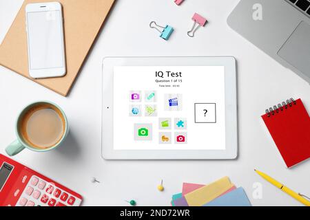 Modern tablet with IQ test on white table, flat lay Stock Photo
