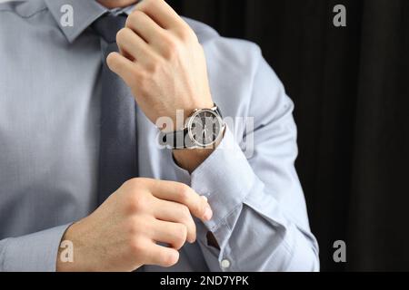 Man with luxury wrist watch on dark background, closeup Stock Photo