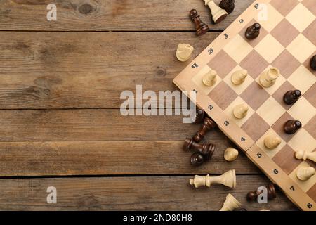 Flat lay composition of chess on wooden table, space for text. Board game Stock Photo