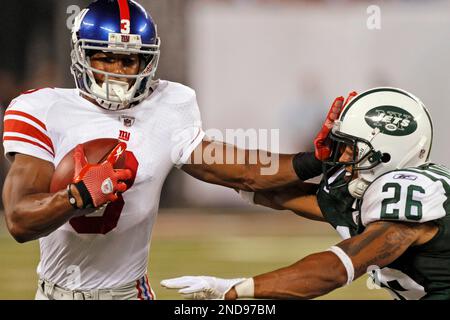 New York Giants Victor Cruz leaps over New York Jets Eric Smith as