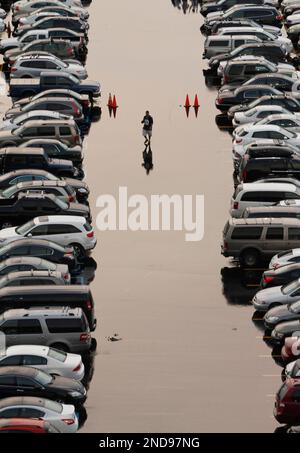 Fans walk through the parking lot during a rain shower at New