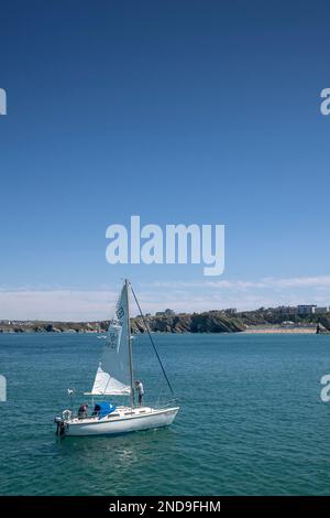 The sailboat Marlene raising sail in Newquay Bay In Cornwall in England in the UK. Stock Photo