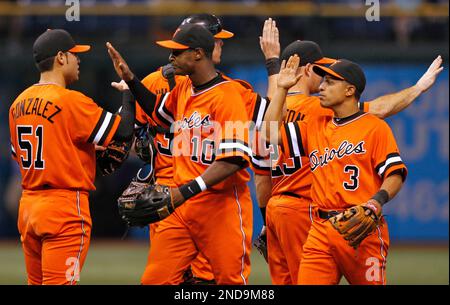 Baltimore Orioles center fielder Adam Jones (10), and Cesar Izturis (3)  celebrate with relief pitcher Mike Gonzalez (51) after the Orioles defeated  the Tampa Bay Rays 5-0 during a baseball game Friday