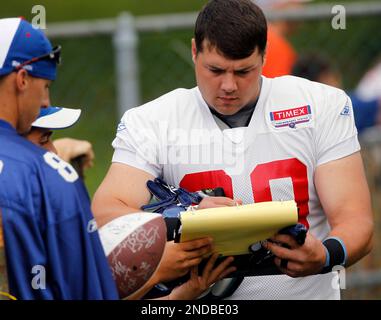 New York Giants fullback Madison Hedgecock (C) tries on high heel shoes  given to him by Kellie Pickler (R) during Media Day at the University of  Phoenix Stadium in Glendale, Arizona, on