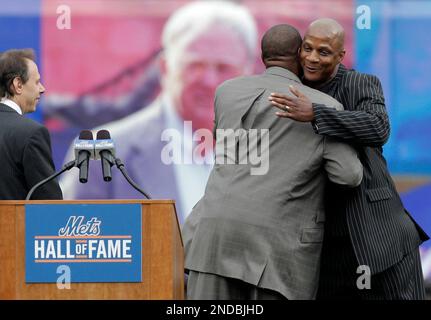 Former New York Mets players Daryl Strawberry and Howard Johnson embrace  after Strawberry throws out the first pitch against the Florida Marlins on  Opening Day at Citi Field in New York City