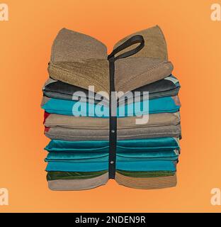 Stack of colorful decorative pillows tied in a bow isolated on yellow background Stock Photo