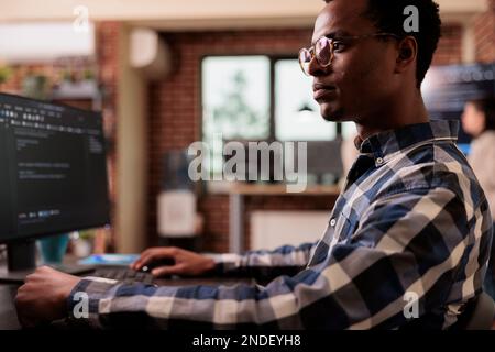 Software developers working with html script on terminal window, looking at computer screen and typing. IT system engineer writing ai algorithm and sitting at desk in it startup company. Stock Photo
