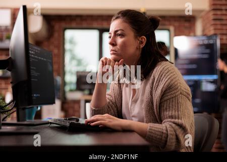 Freelance coder working with html script on terminal window, looking at computer screen and typing. Caucasian tech enginners writing innovating ai algorithm it developing it agency Stock Photo