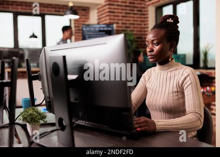 African american tech enginner typing big data code on computer, developing program using html script. Software developer writing ai algorithm working in it programming agency Stock Photo