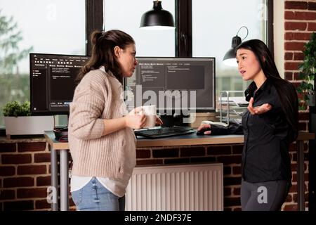 Diverse tech enginners developing software algorithm for information processing and network optimization. Software developers programming application working in it company office Stock Photo