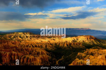 The fading touch of sunlight on Bryce Canyon as sunset draws near, highlighting the textures and colors of the rock formations. Stock Photo
