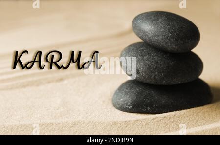 Karma concept. Stacked stones on sand, closeup Stock Photo