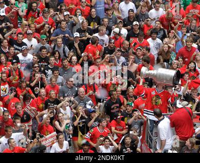 Patrick Kane kisses the Stanley Cup as passes fans as the Chicago