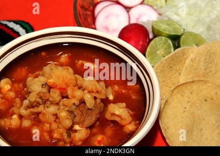 Typical Mexican food, plate of pozole with corn, meat, vegetables and toasts Stock Photo