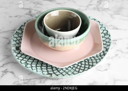Stack of clean dishes on white marble table Stock Photo