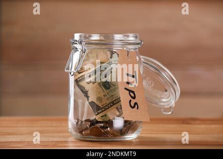 Glass jar with tips on wooden table, closeup Stock Photo