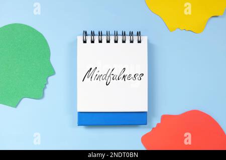 Mindfulness and mindful living concept. Word written on blue notepad with human head profile silhouette. Stock Photo