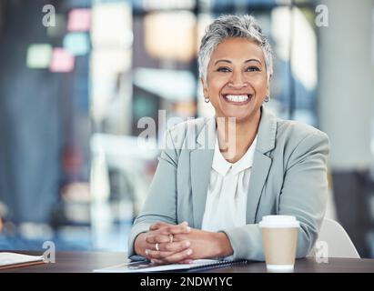 Ready, business and portrait of a woman in corporate for working, success and goals. Smile, happy and mature office employee sitting at a desk to Stock Photo